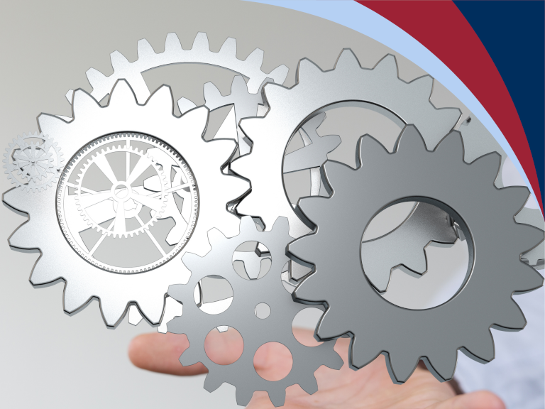 A hand turning a gear set